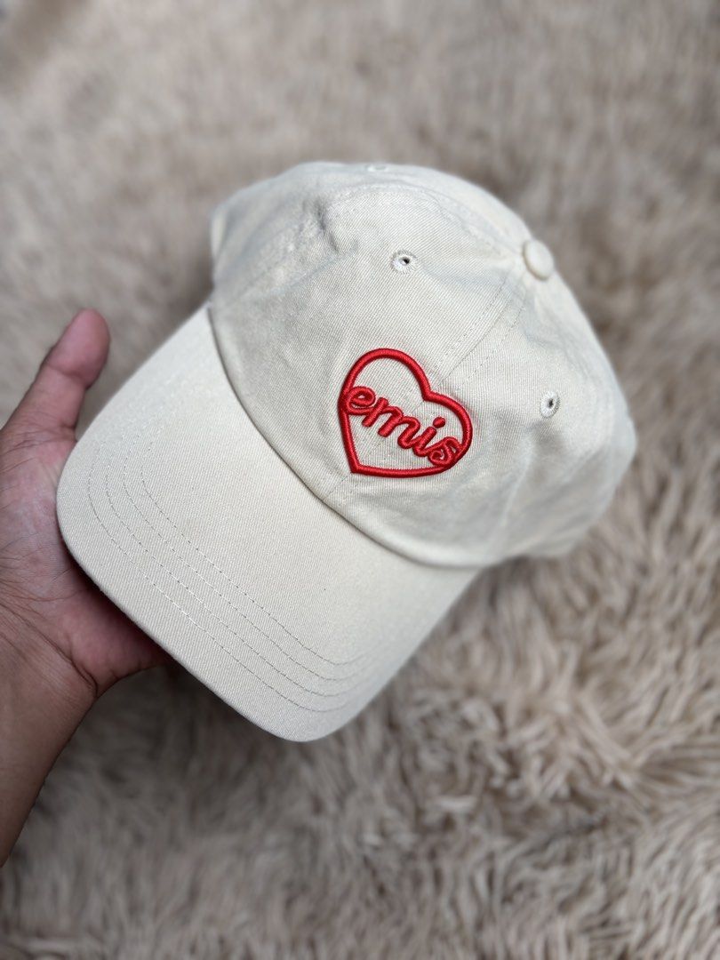 EMIS Heart Logo Baseball Cap Beige (Category: Caps & Hats) located in Quezon City. Submitted by nojthrift (Listing ID 1464252140, Image 2). Description: - Brand: EMIS - Color: Beige - Design: Classic baseball cap - Features: Embroidered red heart logo on front - Fit: Adjustable strap at the back - Style: Perfect for everyday wear.