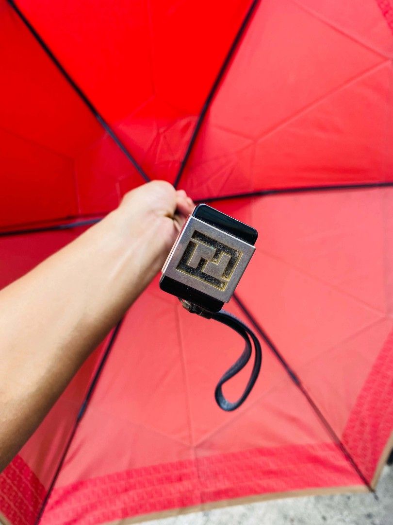 Fendi Red Monogram Umbrella (Category: Umbrellas) located in Caloocan City. Submitted by joshuadyogi0122 (Listing ID 1464165252, Image 2). Description: - Authentic Red Fendi Umbrella - Iconic FF Monogram pattern along the edge - Features a metal Fendi logo detail on the handle - Compact and easy to carry - Perfect for rainy days - Shows some signs of use but remains fully functional.