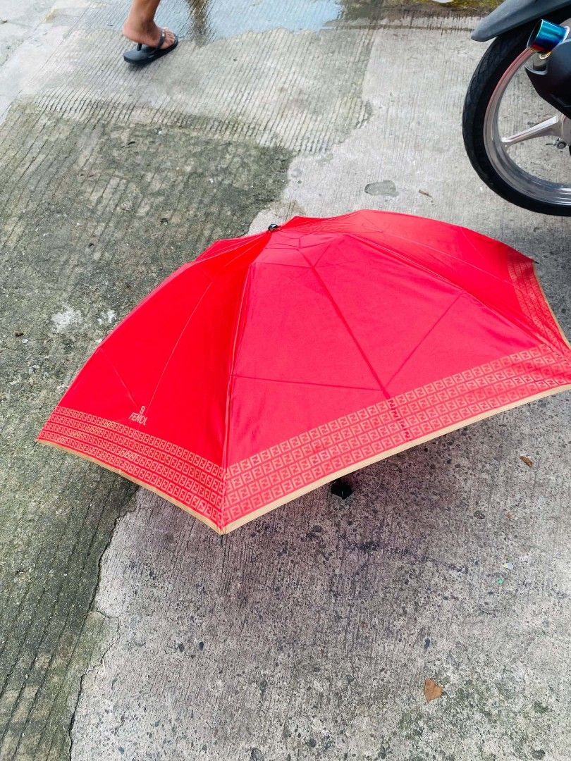 Fendi Red Monogram Umbrella (Category: Umbrellas) located in Caloocan City. Submitted by joshuadyogi0122 (Listing ID 1464165252, Image 1). Description: - Authentic Red Fendi Umbrella - Iconic FF Monogram pattern along the edge - Features a metal Fendi logo detail on the handle - Compact and easy to carry - Perfect for rainy days - Shows some signs of use but remains fully functional.