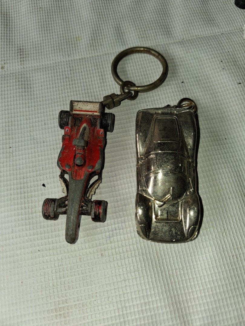 Ferrari & Formula 1 Car Keychains (Category: Vehicle & Diecast Models) located in Manila. Submitted by marcas022798212 (Listing ID 1464148469, Image 1). Description: - Set of 2 car keychains - Includes a silver classic sports car and a red/grey Formula 1 race car - Both come with keyrings attached - Ideal gift for car enthusiasts or a cool personal accessory.