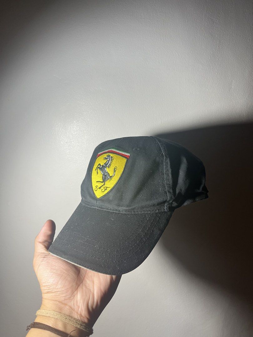 Ferrari Scuderia Formula 1 Racing Cap Hat (Category: Caps & Hats) located in Cavite. Submitted by majaco (Listing ID 1464314375, Image 1). Description: - Iconic black Ferrari cap - Features the Scuderia shield logo embroidered on the front - Adjustable strap at the back for a custom, comfortable fit - One size fits most - Ideal for Formula 1 enthusiasts and Ferrari supporters.
