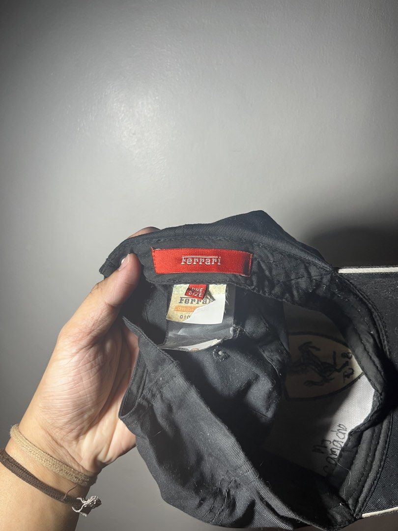 Ferrari Scuderia Formula 1 Racing Cap Hat (Category: Caps & Hats) located in Cavite. Submitted by majaco (Listing ID 1464314375, Image 3). Description: - Iconic black Ferrari cap - Features the Scuderia shield logo embroidered on the front - Adjustable strap at the back for a custom, comfortable fit - One size fits most - Ideal for Formula 1 enthusiasts and Ferrari supporters.