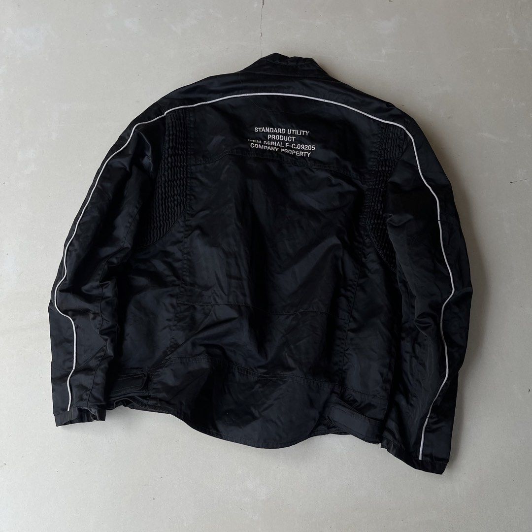 FUBU JEANS COLLECTION Black Jacket Y2k (Category: Coats, Jackets and Outerwear) located in Mandaue City. Submitted by chinsyap_03 (Listing ID 1464190772, Image 3). Description: - Black FUBU JEANS COLLECTION jacket - Size: Medium (M) - Front graphic: "FUBU JEANS COLLECTION" - Back text: "STANDARD UTILITY PRODUCT ITEM SERIAL F-C.09205 COMPANY PROPERTY" - Ideal for casual wear.