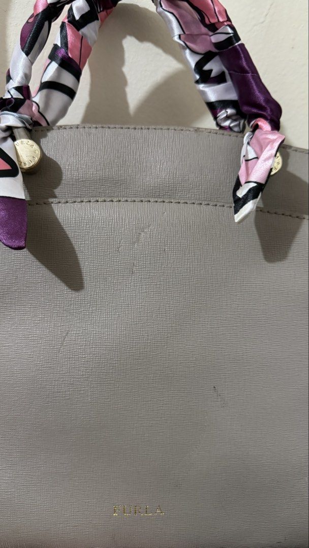 Furla Agata Medium Gray Leather Bag (Category: Luxury Bags & Wallets) located in Rizal. Submitted by lovegclothingph (Listing ID 1464286520, Image 3). Description: - Furla gray leather crossbody bag - Comes with twilly due to damaged handles - Includes a detachable crossbody strap for versatile wear - Features elegant gold hardware details - Secure side zipper closure - With marks present on the bag and base - RFS: Decluttering.