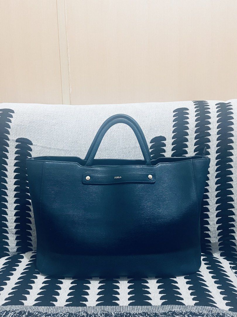 Furla Tote Bag Navy Blue Leather (Category: Tote Bags) located in Quezon City. Submitted by dressuposhoppe (Listing ID 1464208735, Image 1). Description: - Navy blue Furla tote bag - Genuine leather - Spacious interior, ideal for daily essentials - Comfortable top handles - Secure zipper closure - Classic, minimalist design.