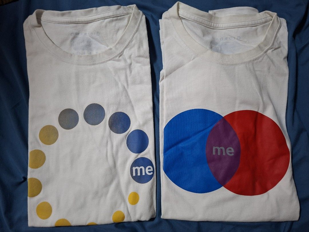 Giordano ME White T-shirts (2 pcs) (Category: Tshirts & Polo Shirts ) located in Paranaque City. Submitted by tabsi76 (Listing ID 1464262060, Image 1). Description: - Two white Giordano ME t-shirts - Size: 180/104A - Design 1: Circular dot pattern - Design 2: Overlapping blue and red circles with 'me' in the center - Ideal for casual everyday wear -Selling as bundle for 250 pesos.