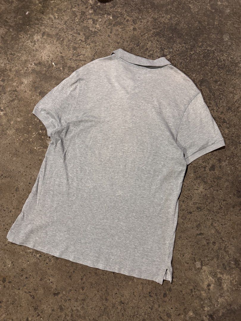 Grey Nike Polo Shirt (Category: Tshirts & Polo Shirts ) located in Pasig City. Submitted by dripthrift1600 (Listing ID 1464248947, Image 2). Description: - Grey Nike polo shirt - Short sleeves with collar and button placket - Features a small Nike swoosh logo on the chest - Versatile for casual wear or sports activities - **Condition Note:** Has a small hole on the back, as shown in the last photo. - Dimes: 21x28.