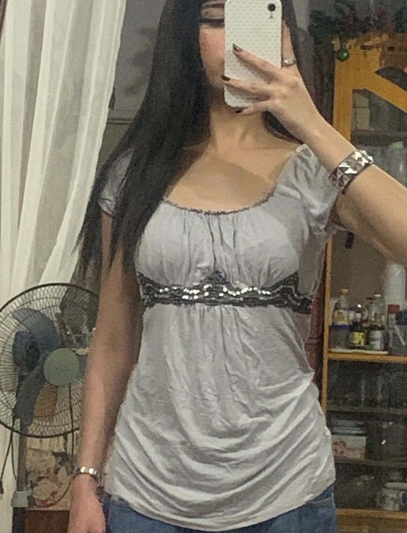 Grey Ruched Top with Beaded Embellishment (Category: Sleeveless) located in Tiaong. Submitted by cdoswan (Listing ID 1464273870, Image 2). Description: - Grey short-sleeved top - Ruched neckline detail - Decorative beaded trim across the chest - Fabric with a slight sheen - Very flattering fit - Perfect for dressing up or down.