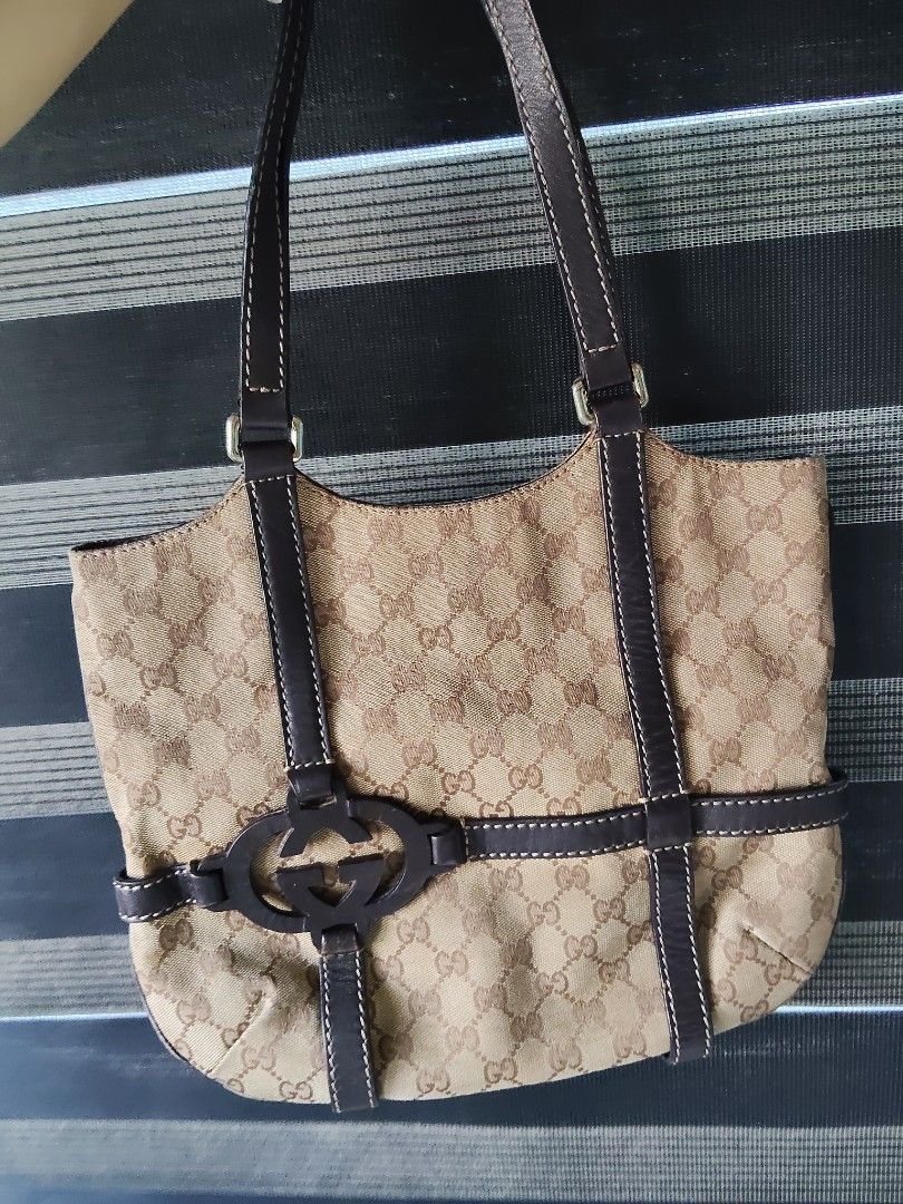 Gucci Monogram Canvas Leather Trim Shoulder Bag (Category: Luxury Bags & Wallets) located in Iba. Submitted by royalgemini (Listing ID 1464195285, Image 1). Description: - Authentic Gucci shoulder bag - Classic GG monogram canvas - Dark brown leather trim and straps - Zipper closure - Interior leather tag with serial number 181502 2123 - Made in Italy - Shows some signs of wear but still a great bag.