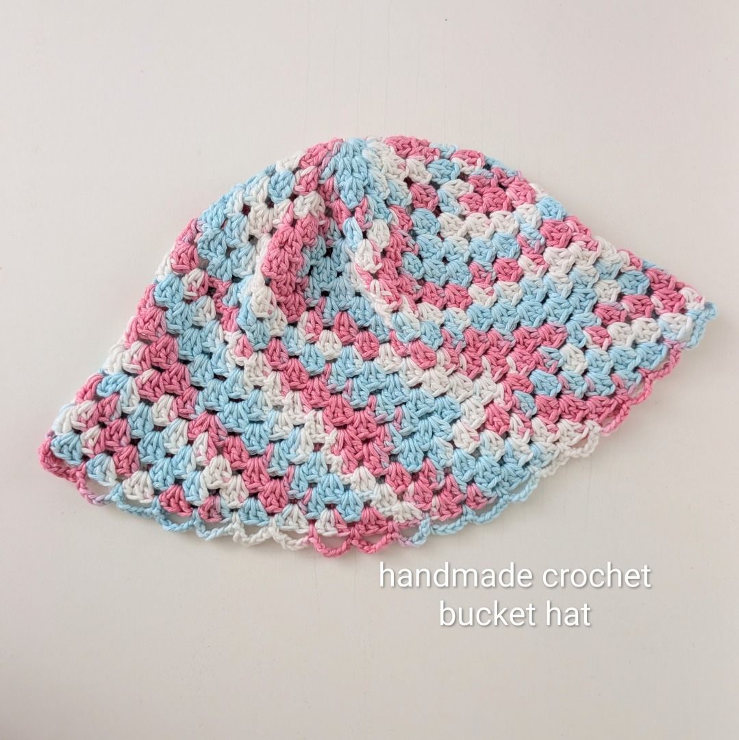 [Handmade] Crochet Bucket Hat - pink, white, blue (Category: Hats & Beanies) located in Quezon City. Submitted by user81204 (Listing ID 1464142389, Image 1). Description: - Crochet bucket hat handmade by me🧶☺️ - Features a colorful granny square pattern (pink, blue, white) - Delicate scalloped edge on the brim - Ideal for sunny days and as a fun accessory - Unique, one-of-a-kind handmade item Size: 52cm circumference 20cm length.