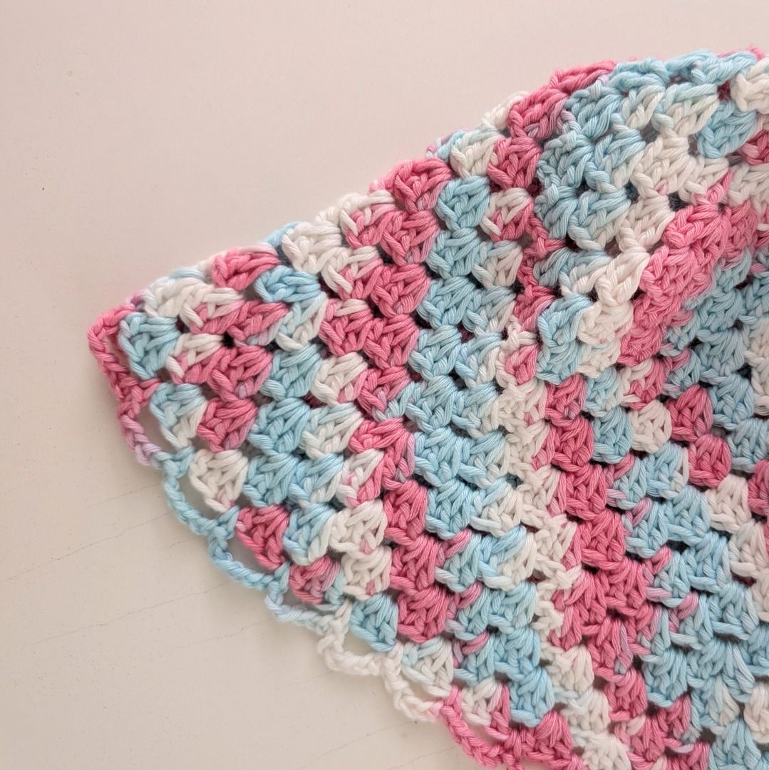 [Handmade] Crochet Bucket Hat - pink, white, blue (Category: Hats & Beanies) located in Quezon City. Submitted by user81204 (Listing ID 1464142389, Image 2). Description: - Crochet bucket hat handmade by me🧶☺️ - Features a colorful granny square pattern (pink, blue, white) - Delicate scalloped edge on the brim - Ideal for sunny days and as a fun accessory - Unique, one-of-a-kind handmade item Size: 52cm circumference 20cm length.
