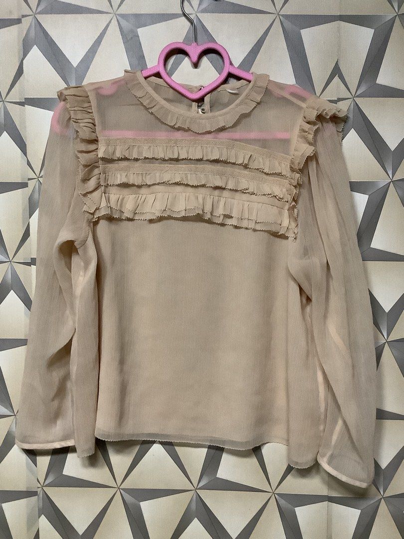H&M Dusty Peach Sheer Ruffle Chiffon Blouse (Category: Blouses) located in Quezon City. Submitted by lovedbyerara (Listing ID 1464271684, Image 1). Description: Design Details: A romantic, vintage-inspired blouse featuring layered pleated ruffles arranged horizontally across the upper chest and accenting the shoulders. It is designed with a mock-neckline trimmed with a subtle mini-frill, long flowing sleeves, and a clean finished hem. Material & 