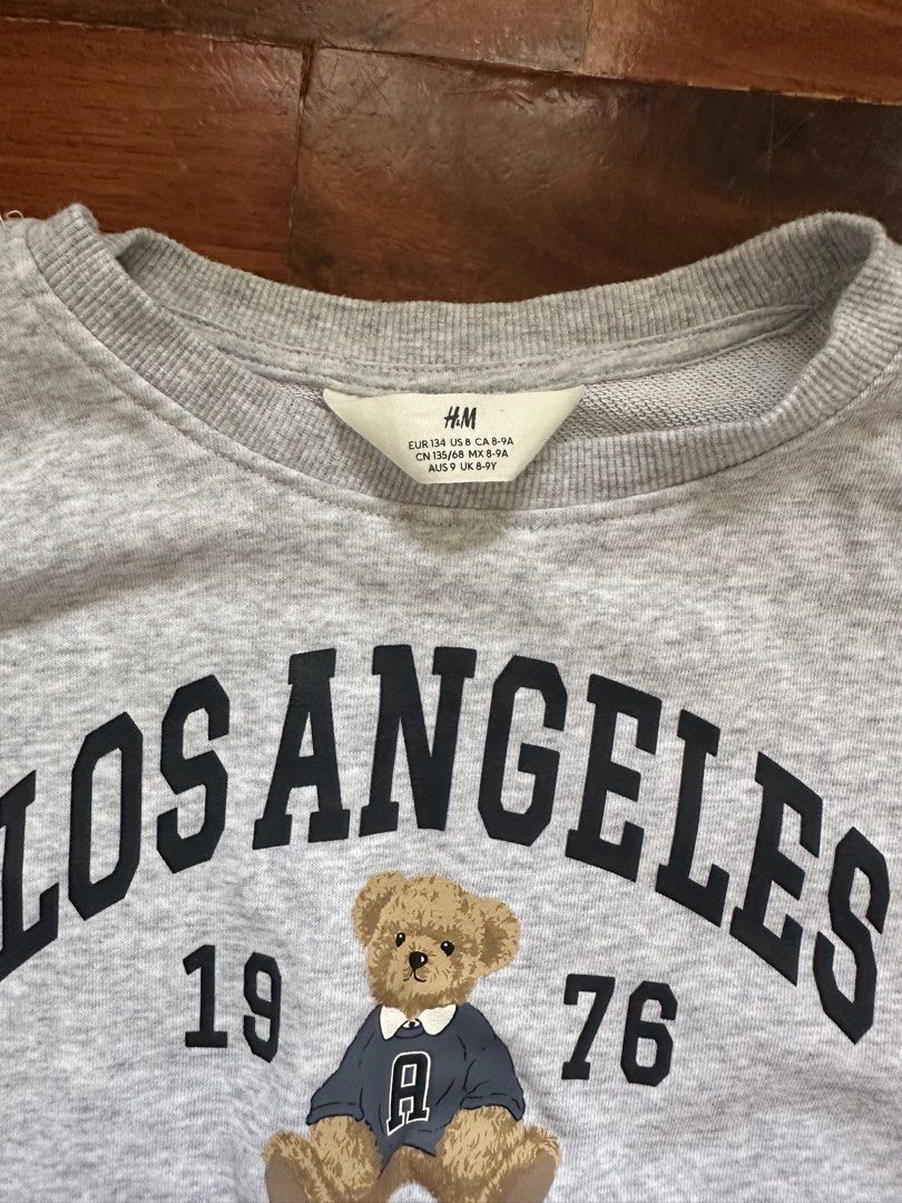 H&M Grey Los Angeles Teddy Bear Sweatshirt (Category: Coats, Jackets and Outerwear) located in Cainta. Submitted by buy.preloved (Listing ID 1464218331, Image 2). Description: - Grey H&M sweatshirt - Features 'Los Angeles 1976' graphic with a teddy bear - Crew neck, long sleeves - Cropped fit - Ideal for casual wear.