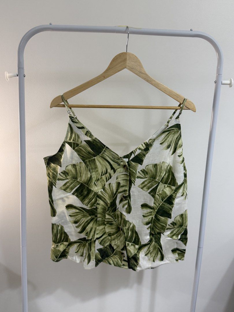 H&M Linen Blend Leaf Print Camisole Top (Category: Sleeveless) located in Cebu City. Submitted by jnnwright (Listing ID 1464170576, Image 1). Description: - Cute H&M camisole top - White with green leaf print - Adjustable straps - Button details down the front - Made from a linen blend - Versatile for casual or dressed-up looks.