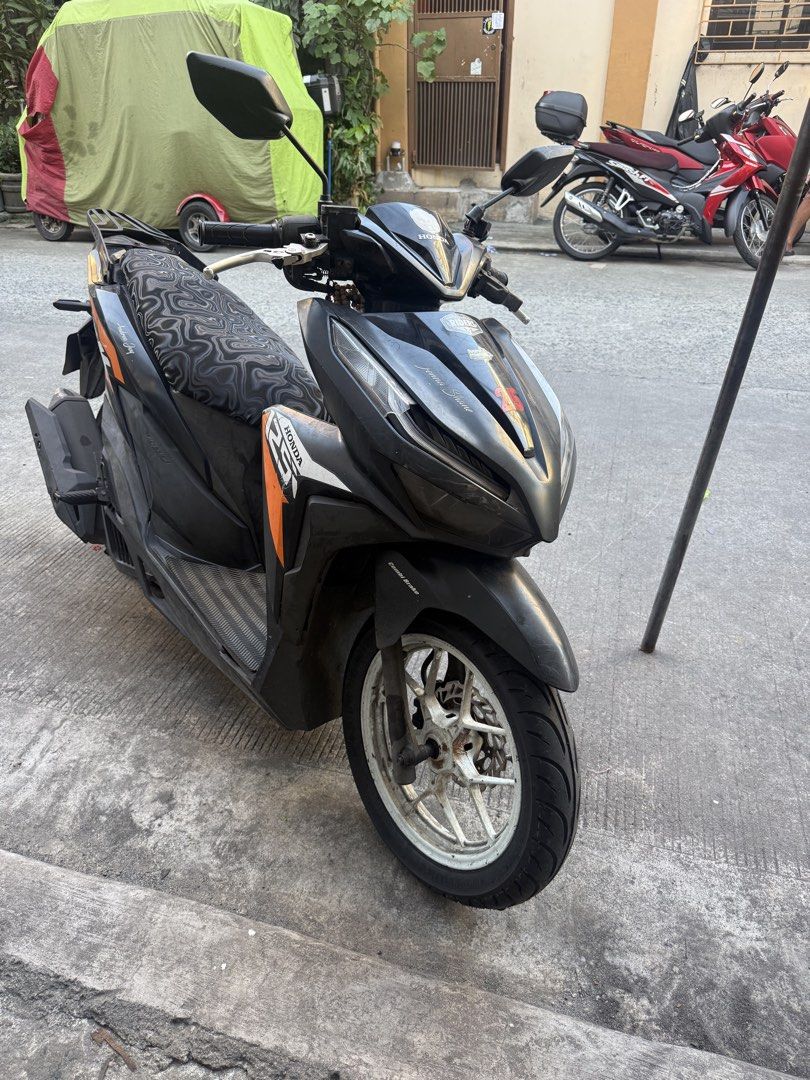 Honda Click 125i Scooter (Category: Motorbikes for Sale) located in Manila. Submitted by lexii_lexii (Listing ID 1464314330, Image 1). Description: Selling my Honda Click 125i. Black with orange accents. Custom seat cover with a cool pattern. Runs well. Ready for a new owner. Great for city commuting. Message me for more details..