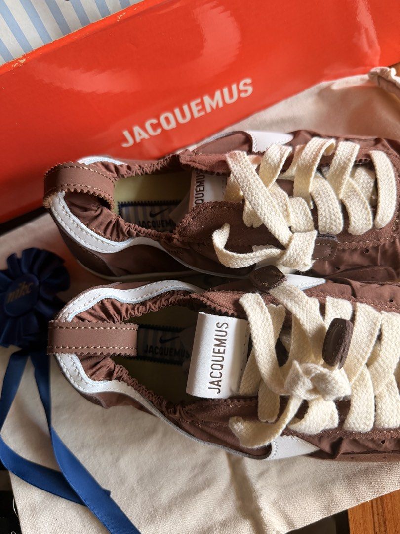 Jacquemus x Nike Brown Sneakers (Category: Sneakers) located in Las Pinas. Submitted by twiceloved24 (Listing ID 1464176623, Image 1). Description: SIZES AVAILABLE - Unique gathered nylon upper with stylish white accents. - Cream laces for a clean finish. - Distinctive textured sole for added grip and style. - Comes complete with original box and dust bag..
