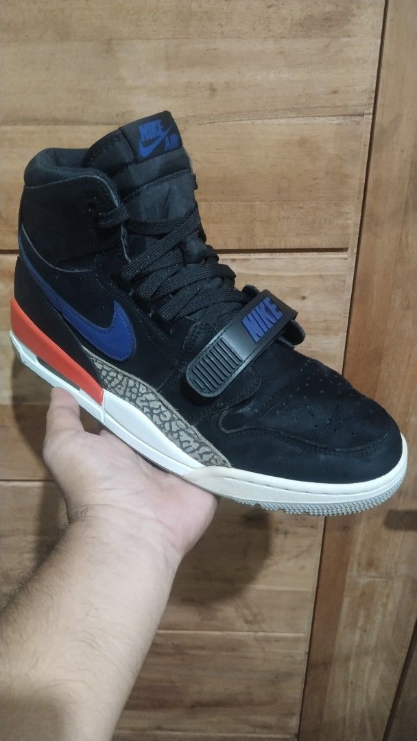 Jordan Legacy 312 High Cut Knicks (Category: Sneakers) located in Manila. Submitted by bigbenplaysthriftstore (Listing ID 1464294034, Image 2). Description: - Black high-top sneakers - Blue and red accent details - Iconic elephant print on the midsole - Adjustable midfoot strap with Nike branding - Jordan branding on heel and sole - Ideal for casual wear or playing basketball.