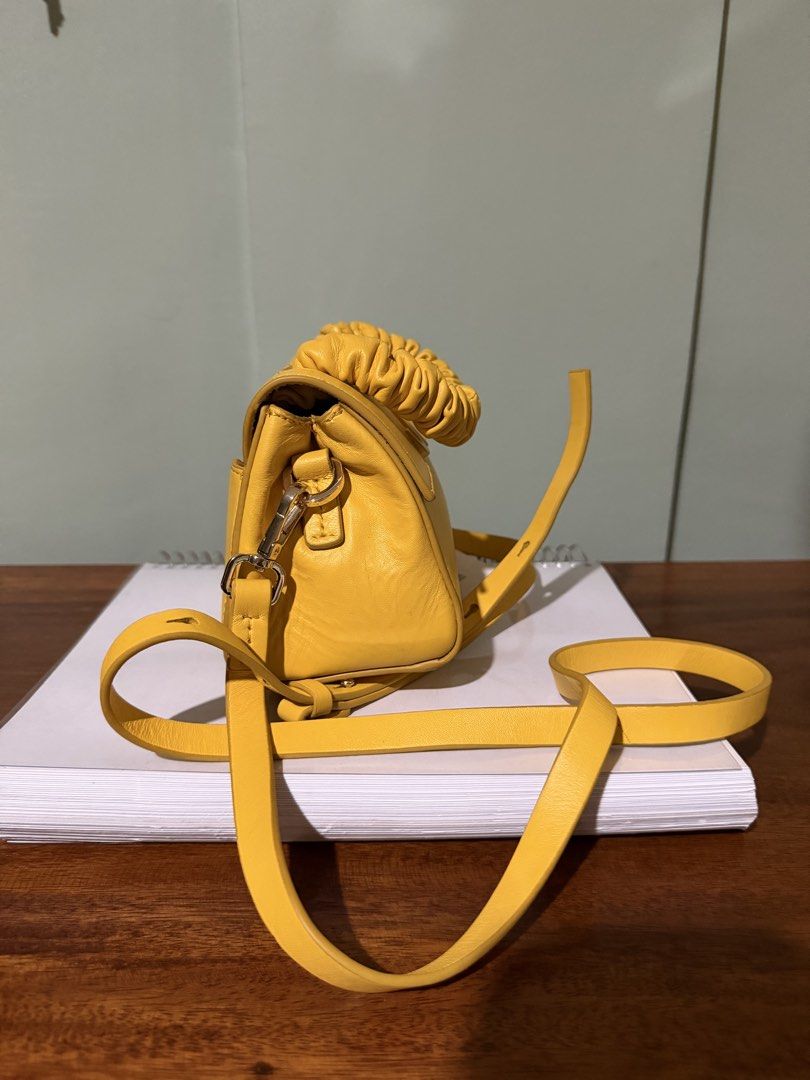 JW Yellow Leather Top Handle Bag with Strap (Category: Luxury Bags & Wallets) located in Las Pinas. Submitted by joelturla (Listing ID 1464228379, Image 3). Description: - Negotiable - Yellow leather handbag - Prominent JW logo on the front - Stylish ruched top handle - Includes a detachable shoulder strap for versatility - Elegant gold hardware details - 'JASON WU' logo embossed on the back - Adds a vibrant pop of color to any outfit.
