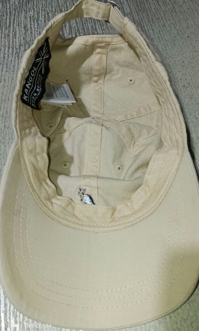 Kangol (Category: Caps & Hats) located in Quezon City. Submitted by Bernz (Listing ID 1464326725, Image 3). Description: Design: Unstructured, 6-panel crown crafted from durable cotton twill fabric with top ventilation eyelets.Colorway: Cream / Off-White / Khaki with a signature navy blue embroidered kangaroo logo centered on the front panels.Fit Details: Curved brim stitched panel with an adjustable strap closure at the back, commonly finished w