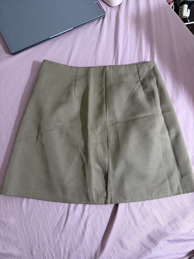 Khaki A-line Mini Skirt (Category: Skirts) located in San Fernando. Submitted by iammaryjoy58877 (Listing ID 1464153726, Image 1). Description: - Classic khaki A-line mini skirt - Simple and timeless design - Features a slight slit at the front - Perfect for both casual and dressy occasions - Effortlessly pairs with various tops.