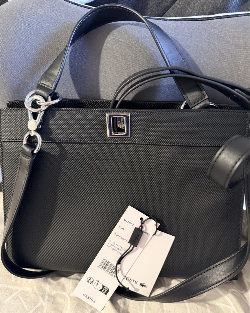 Lacoste Black Top Handle Bag (Category: Tote Bags) located in Pasig City. Submitted by moms_closet2024 (Listing ID 1464168664, Image 1). Description: - Authentic Black Lacoste Top Handle Bag - Material: 100% Polyester with Polyurethane Coating - Features a Detachable Shoulder Strap - Comes with Original Tags - Dimensions: 10 inches wide.