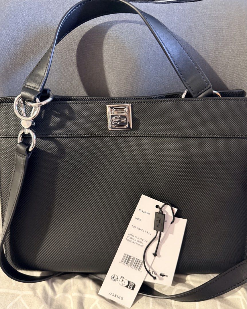 Lacoste Black Top Handle Bag (Category: Tote Bags) located in Pasig City. Submitted by moms_closet2024 (Listing ID 1464168664, Image 2). Description: - Authentic Black Lacoste Top Handle Bag - Material: 100% Polyester with Polyurethane Coating - Features a Detachable Shoulder Strap - Comes with Original Tags - Dimensions: 10 inches wide.