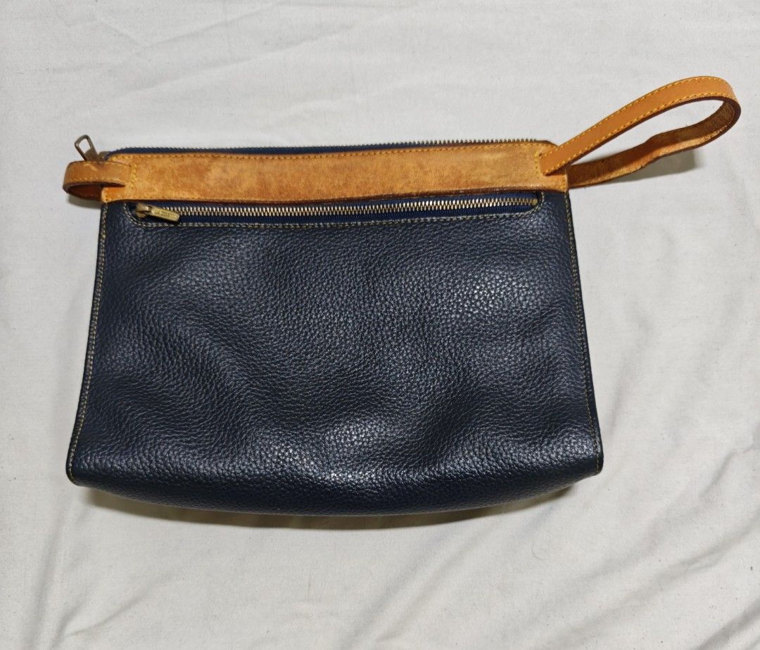 Lacoste Leather Pouch Clutch Bag (Category: Purses & Pouches) located in Isulan. Submitted by jaysthrift (Listing ID 1464225134, Image 3). Description: - Classic black and tan leather pouch by Lacoste. - Ideal size for carrying your essentials. - Secure zipper closure to keep items safe. - Interior features a small leather tag with the iconic Lacoste logo. - Convenient wrist strap attached for easy carrying. - Approximate dimensions: 9 inches wid