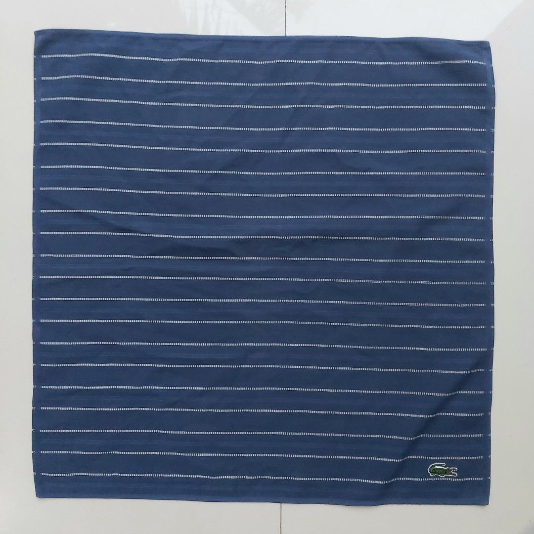 Lacoste Navy Blue Striped Handkerchief (Category: Handkerchief & Pocket Squares) located in Lapu Lapu. Submitted by agnesapm_29813 (Listing ID 1464259564, Image 3). Description: - Navy blue handkerchief with classic white stripes - Features the iconic embroidered Lacoste crocodile logo - Made from soft, comfortable cotton material - Perfect for everyday use or as a stylish accessory - Approximate dimensions: 17 inches x 17 inches - Washed and iro