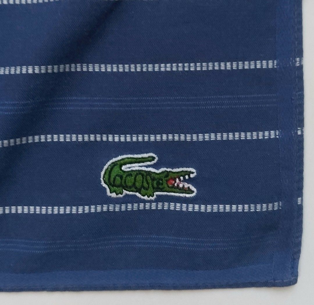 Lacoste Navy Blue Striped Handkerchief (Category: Handkerchief & Pocket Squares) located in Lapu Lapu. Submitted by agnesapm_29813 (Listing ID 1464259564, Image 1). Description: - Navy blue handkerchief with classic white stripes - Features the iconic embroidered Lacoste crocodile logo - Made from soft, comfortable cotton material - Perfect for everyday use or as a stylish accessory - Approximate dimensions: 17 inches x 17 inches - Washed and iro
