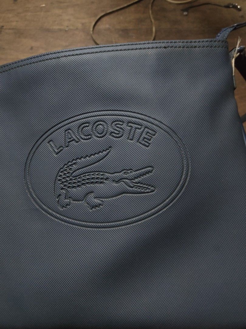 Lacoste Sleek Blue crossbody bag (Category: Luxury Bags & Wallets) located in Manila. Submitted by montillano25396 (Listing ID 1464317016, Image 2). Description: Lacoste Sleek Blue crossbody bag Size: Medium Good Condition Issue: minimal crack spot inside.