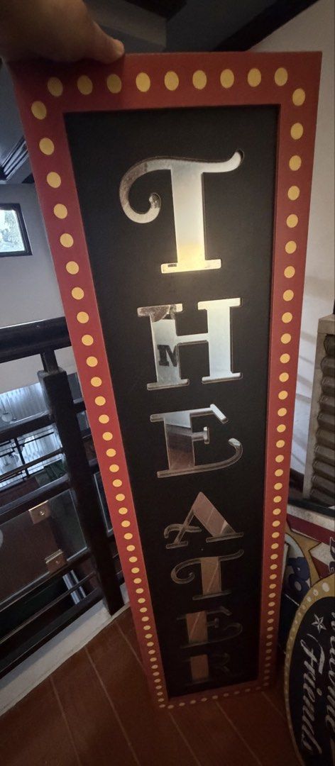Large "THEATER" Marquee Sign with Mirrored Letters (Category: Wall Decor) located in Quezon City. Submitted by things.matter (Listing ID 1464308745, Image 2). Description: - Large decorative 'THEATER' sign - Each letter is mirrored - Black background with red border and yellow dots - Marquee-style design - Ideal for home theater rooms or themed parties - Substantial size -47x12”.
