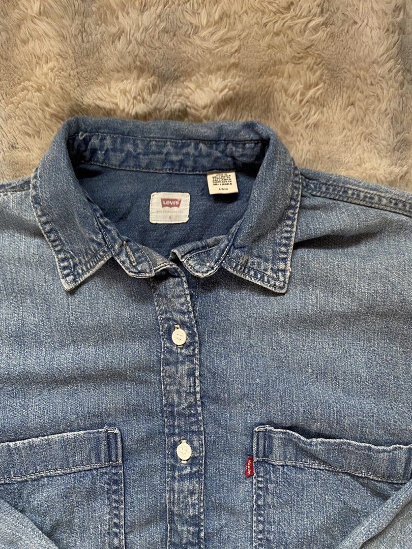 Levi's Denim Shirt Blue Size S (Category: Coats, Jackets and Outerwear) located in Andop. Submitted by safewater-895a (Listing ID 1464197464, Image 3). Description: - Classic Levi's denim shirt - Blue wash - Two chest pockets with button closure - Button-up front - Long sleeves with button cuffs - 100% cotton - Tagged S/P/CH - Width: 24 - Lenght: 27.