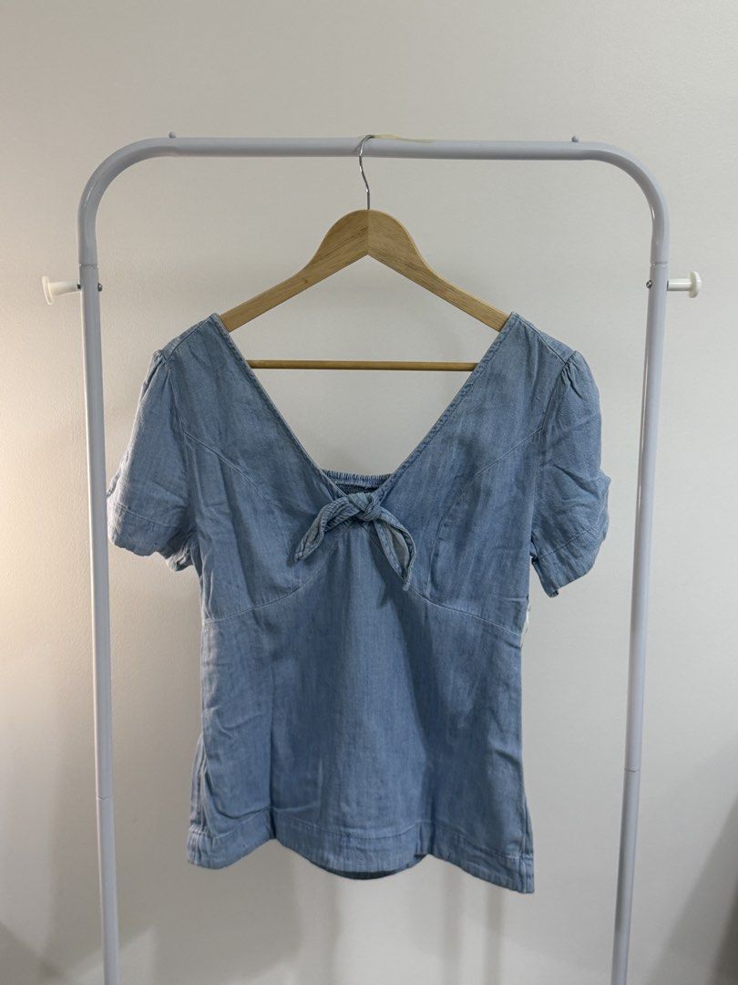 Light Wash Denim V-Neck Tie Front Top (Category: Blouses) located in Cebu City. Submitted by jnnwright (Listing ID 1464168808, Image 1). Description: - Light wash denim V-neck top - Features a tie detail at the front - Short sleeves with a slight puff - Versatile: pairs well with jeans or shorts - Ideal for casual outings.