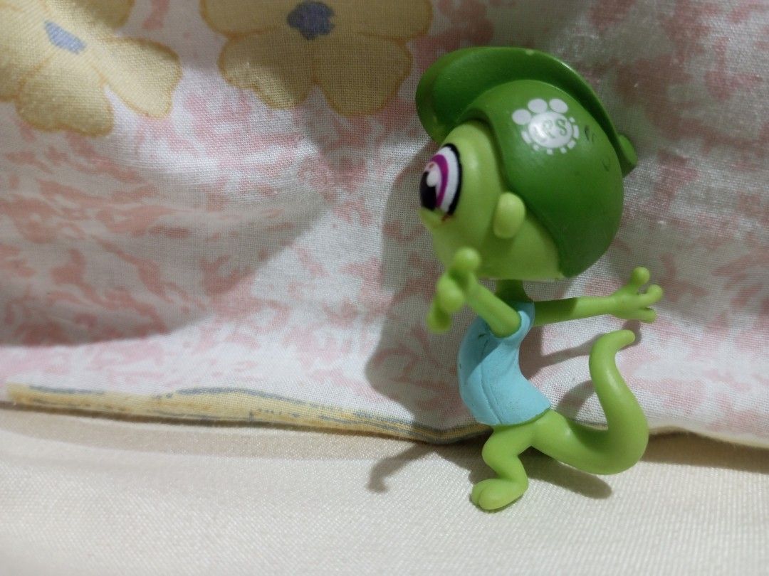 Littlest Pet Shop Green Lizard Toy (Category: Kids Toys) located in Victorias. Submitted by tobylacua26871 (Listing ID 1464270764, Image 2). Description: - Adorable green Littlest Pet Shop lizard toy. - Features big, captivating purple eyes. - Comes with a cute light blue shirt. - Distinctive LPS logo imprinted on its head. - Ideal for Littlest Pet Shop collectors and young fans. - Compact size makes it easy to carry and play with. - Ready to fin