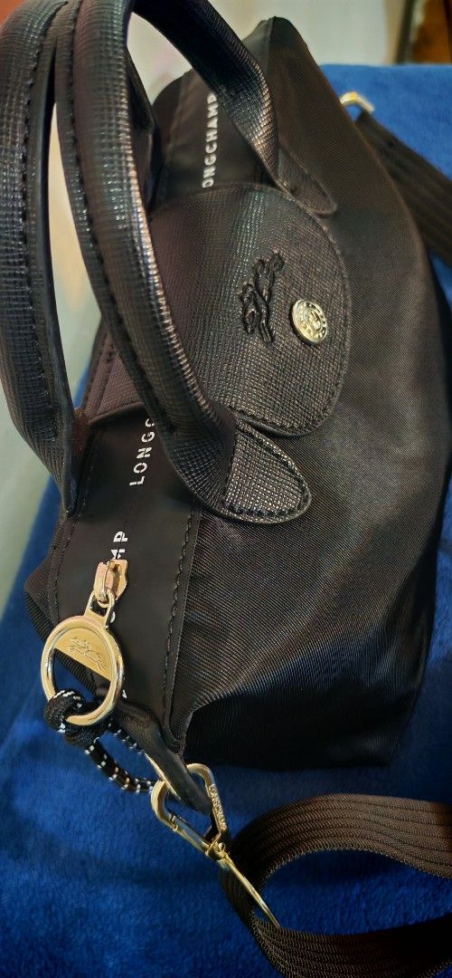 Longchamp Le Pliage Neo Small Top Handle Bag Black (Category: Luxury Bags & Wallets) located in Caloocan City. Submitted by miyaka_lm (Listing ID 1464202529, Image 3). Description: - Black Longchamp - Small size, ideal for daily use - Versatile: Top handles and detachable shoulder strap - Secure zipper closure - Made in France - Signature Longchamp logo details on snap button and zipper pull - Brand name printed along zipper trim.