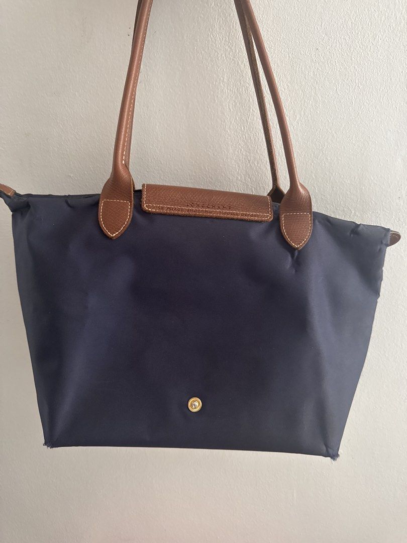 Longchamp Le Pliage Tote Bag Navy Blue (Category: Luxury Bags & Wallets) located in Manila. Submitted by decluterthings888 (Listing ID 1464337500, Image 2). Description: - Classic Longchamp Le Pliage tote bag - Color: Navy blue nylon with brown leather handles and trim - Closure: Zipper with snap button flap - Features: Interior pocket - Practicality: Folds flat for easy storage - Style: Timeless and perfect for everyday use.
