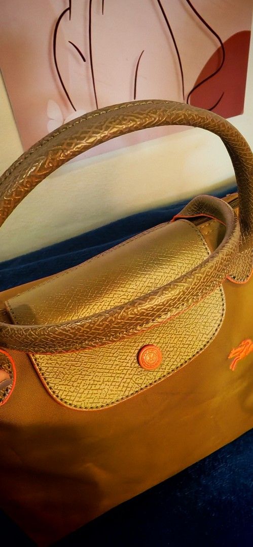 Longchamp Paris Le Pliage Top Handle Bag (Category: Luxury Bags & Wallets) located in Caloocan City. Submitted by miyaka_lm (Listing ID 1464198000, Image 2). Description: - Authentic Longchamp Paris handbag - Color: Bronze/Gold - Material: Nylon body with leather trim - Features iconic horse logo - Zipper closure - Made in France - Ideal for everyday use.