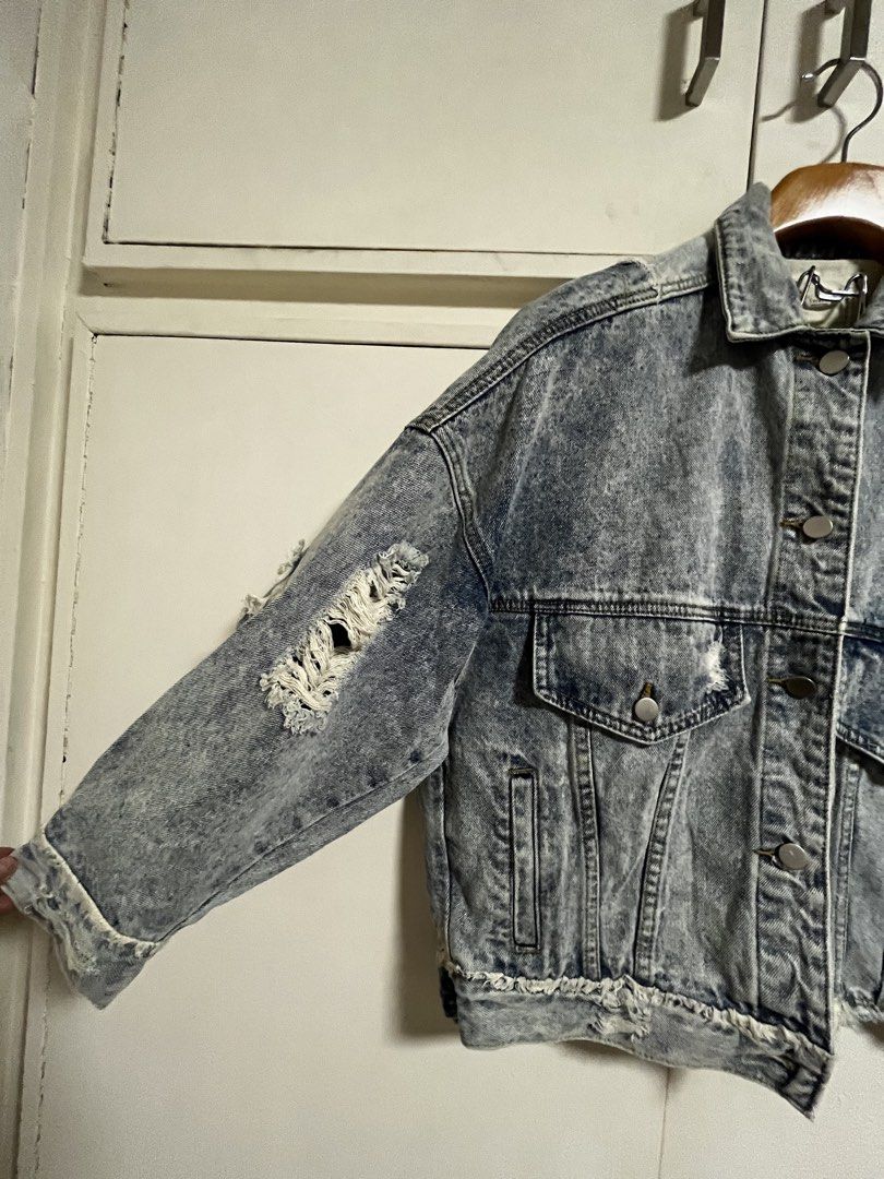 Luckyyyy Distressed Denim Jacket Size S (Category: Coats, Jackets and Outerwear) located in Manila. Submitted by lorenasant37621 (Listing ID 1464217627, Image 2). Description: - Acid wash denim jacket by Luckyyyy - Features distressed and ripped detailing throughout - Button-up front closure - Two chest pockets - Raw hemline and cuffs - Estimated size: Small (S) - Ideal for a casual and edgy aesthetic.