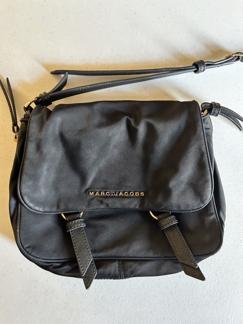 Marc Jacobs Black Nylon Crossbody Bag (Category: Cross-body Bags) located in Roxas City. Submitted by preloved_by_workingstudent (Listing ID 1464206324, Image 2). Description: HEARING OFFERS! Issue: Hardware - Gold Tone (signs of tarnish due to wash) bought in-store NOT UKAY Authentic Black Marc Jacobs Crossbody Bag Black Top Magnetic Button Closure Exterior: Nylon, Leather Trim. Interior: Nylon 11" L x 3.5" D x 7.5" H Long Handle Drop Length: 20
