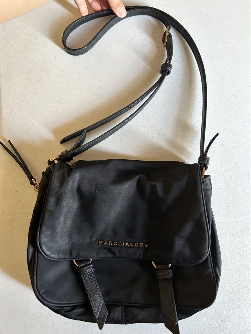 Marc Jacobs Black Nylon Crossbody Bag (Category: Cross-body Bags) located in Roxas City. Submitted by preloved_by_workingstudent (Listing ID 1464206324, Image 1). Description: HEARING OFFERS! Issue: Hardware - Gold Tone (signs of tarnish due to wash) bought in-store NOT UKAY Authentic Black Marc Jacobs Crossbody Bag Black Top Magnetic Button Closure Exterior: Nylon, Leather Trim. Interior: Nylon 11" L x 3.5" D x 7.5" H Long Handle Drop Length: 20