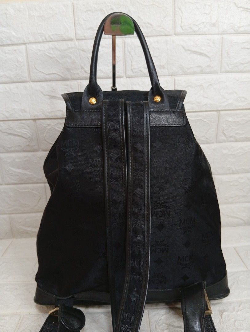 MCM Canvas/Leather Monogram Black Backpack (Category: Backpacks) located in Las Pinas. Submitted by etoksi1234 (Listing ID 1464201966, Image 2). Description: Stylish MCM backpack in black with canvas monogram print. Features leather trim, gold hardware, drawstring and flap closure, front pockets, and adjustable straps. Perfect for everyday use..