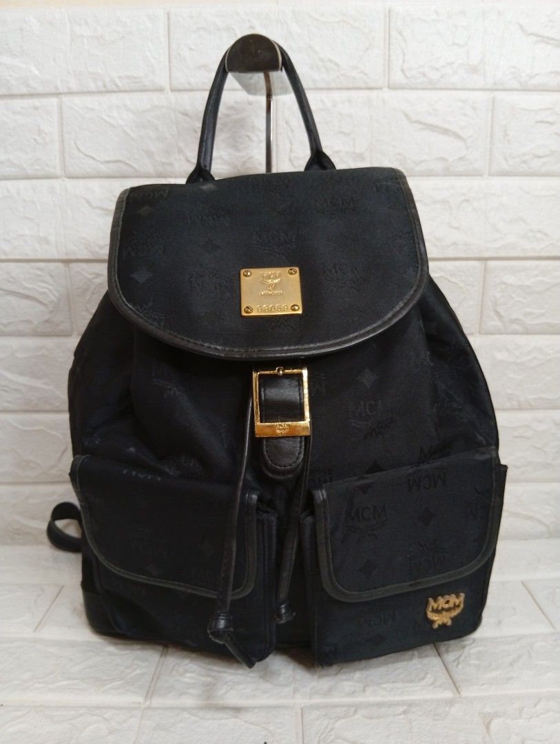 MCM Canvas/Leather Monogram Black Backpack (Category: Backpacks) located in Las Pinas. Submitted by etoksi1234 (Listing ID 1464201966, Image 1). Description: Stylish MCM backpack in black with canvas monogram print. Features leather trim, gold hardware, drawstring and flap closure, front pockets, and adjustable straps. Perfect for everyday use..