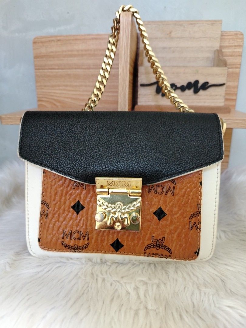 MCM Mini Patricia Color block (Category: Luxury Bags & Wallets) located in Lucena. Submitted by gracious_chin0436 (Listing ID 1464141928, Image 1). Description: - Iconic MCM shoulder bag - Classic monogram print on front flap - Stylish black and white color blocking - Elegant gold chain strap - Secure lock closure - Versatile for day or night use - Handbag only missing long strap for crossbody - Normal to minimal sign of used on metal hardwares s