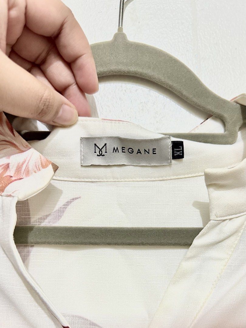 Megane White Floral Long Sleeve Button Up Blouse (Category: Rompers) located in Manila. Submitted by tia_beanie13 (Listing ID 1464183180, Image 3). Description: - Brand: Megane - Color: White with pink and maroon floral print - Sleeves: Long with button cuffs - Neckline: Collarless - Closure: Button-up front - Fit: Defined waistline - Style: Versatile, great for dressing up or down.