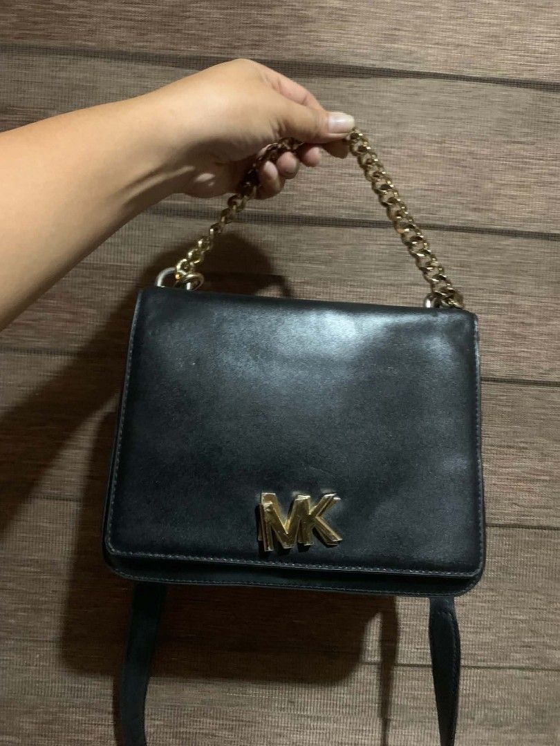 Michael Kors Black Leather Chain Shoulder Bag (Category: Cross-body Bags) located in Aliaga. Submitted by akishaoshop2010. (Listing ID 1464139082, Image 1). Description: - Authentic Michael Kors black leather shoulder bag - Features iconic gold MK logo on the front - Stylish gold chain strap - Interior is clean and well-maintained - Versatile for everyday use or evening events - Selling because it's no longer being used - Feel free to ask any que