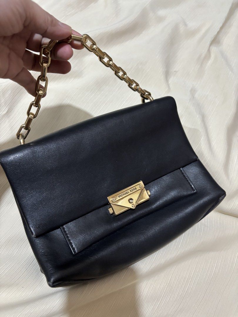 Michael Kors Black Leather Chain Shoulder Bag (Category: Luxury Bags & Wallets) located in Makati City. Submitted by issa124 (Listing ID 1464319245, Image 1). Description: - Authentic Michael Kors black leather shoulder bag - Elegant gold chain strap - Iconic Michael Kors lock closure - Spotless interior - Versatile for day or evening use - Very minimal signs of wear - Ready for its new owner! - Shoulder or hand bag -issue: rubs on all corners as