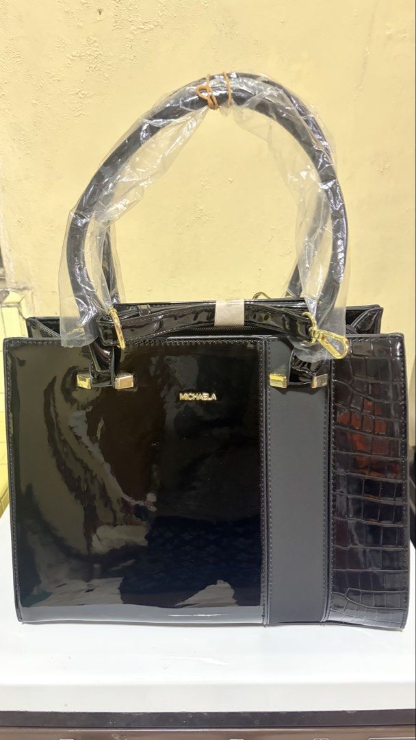 MICHAELA Black Patent Croc Tote Bag (Category: Luxury Bags & Wallets) located in Manila. Submitted by lizziedear.lizziedear (Listing ID 1464147937, Image 1). Description: - Sleek black patent leather handbag - Elegant croc-embossed trim - Polished gold hardware details - Versatile top handles and detachable shoulder strap - Convenient back pocket with zipper closure - Comes with original tags attached - Ideal for both professional settings and ev