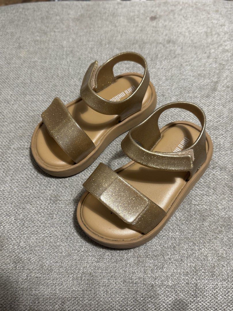 Mini Melissa Gold Glitter Sandals (Category: Babies & Kids Fashion) located in Mandaluyong City. Submitted by anj_declutters (Listing ID 1464214841, Image 2). Description: - Mini Melissa Gold Glitter Sandals - Easy velcro straps for quick on and off - Made in Brazil - Vegan material - Size: 13.5 JPN / 22/23 EUR / 7 USA.