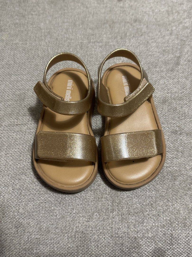 Mini Melissa Gold Glitter Sandals (Category: Babies & Kids Fashion) located in Mandaluyong City. Submitted by anj_declutters (Listing ID 1464214841, Image 1). Description: - Mini Melissa Gold Glitter Sandals - Easy velcro straps for quick on and off - Made in Brazil - Vegan material - Size: 13.5 JPN / 22/23 EUR / 7 USA.