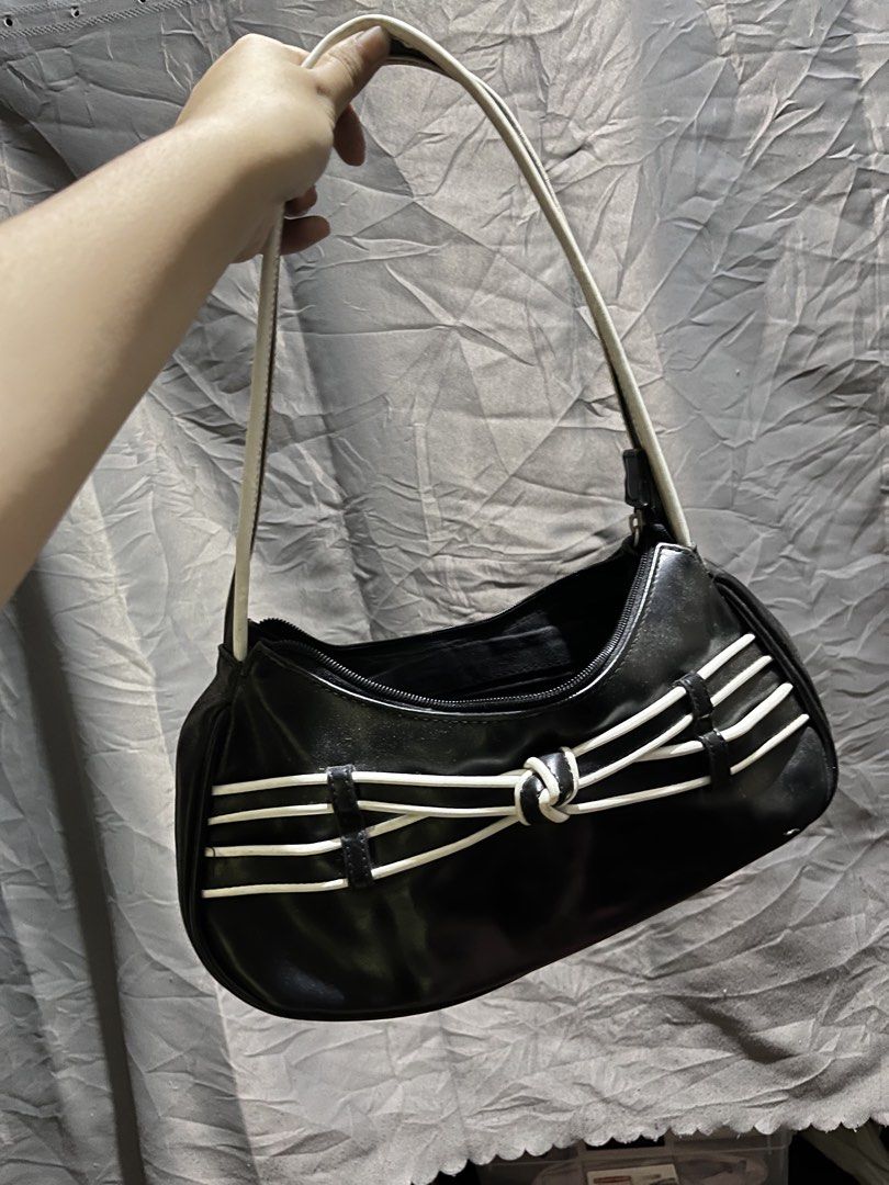 Minicci Black Shoulder Bag with White Trim (Category: Shoulder Bags) located in Bacolod City. Submitted by fuzkisnz (Listing ID 1464245493, Image 1). Description: - Brand: Minicci - Color: Black with white trim - Design: Cute knot detail on the front - Closure: Zipper - Interior: Multiple compartments, including one with a zipper - Exterior: Small zipper pocket on the back - Style: Great for everyday use.